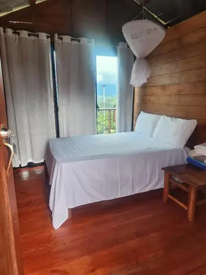 a bedroom with a white bed and a window at Ecocamping Aventura in Boca de Cana