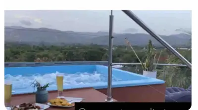 a blue swimming pool with a view of mountains at Casa con jacuzzi in Santiago de los Caballeros