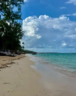 a beach with people swimming in the ocean at Jojo's Caribbean Retreat in Punta Cana