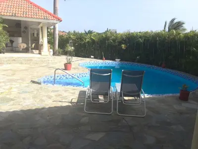 two chairs sitting in front of a swimming pool at Villa vacances de reve in Sosúa
