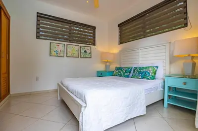 a bedroom with a white bed and two blue tables at Casa Linda Villa 767 - Sosua in Sosúa