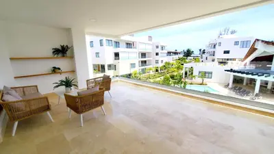 a large living room with a large window and a pool at Amare Residences - Beachfront complex in Las Terrenas