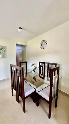 a dining room with a table and chairs and a clock at Oasis de Paz 04 in Colorado
