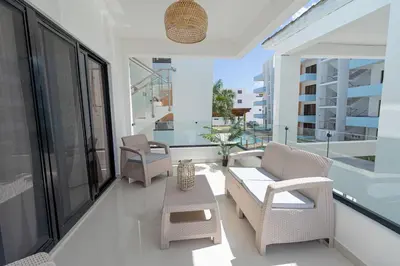 a balcony with two chairs and a table and some windows at Modern 1BR Retreat Central Bayahibe Sunshine in San Rafael del Yuma