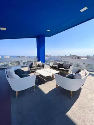 a balcony with couches and tables on a roof at Comodo departamento centrico SD in Santo Domingo