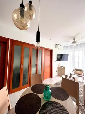 a dining room with a table and some lights at Comodo departamento centrico SD in Santo Domingo