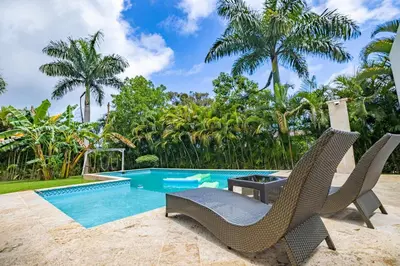 a swimming pool with two chairs and a table next to a pool at Casa Linda Villa 722 - Sosua - BBQ - Washer in Sosúa