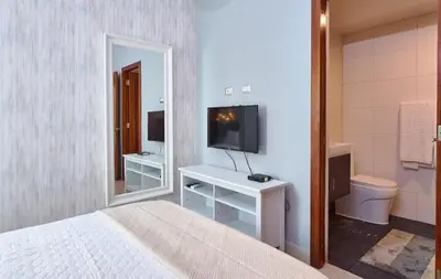 a bedroom with a bed and a tv and a mirror at YOUR SPACE IN SANTO DOMINGO Gazcue in Colorado