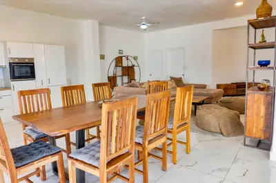 a kitchen and dining room with a wooden table and chairs at Grecialandia in San Felipe de Puerto Plata