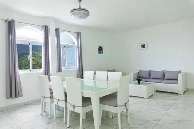 a dining room with a table and chairs and a couch at Grecialandia in San Felipe de Puerto Plata