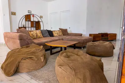 a living room with couches and ottomans at Grecialandia in San Felipe de Puerto Plata