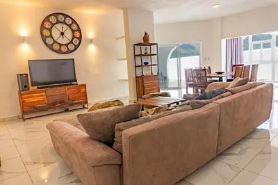 a living room with a large couch and a television at Grecialandia in San Felipe de Puerto Plata