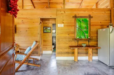 a wooden room with a table and a refrigerator at La Casita Primavera-Cozy and Rustic in Piedra Blanca