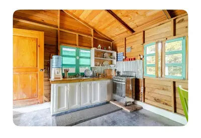a kitchen with a stove and a sink in a cabin at La Casita Primavera-Cozy and Rustic in Piedra Blanca