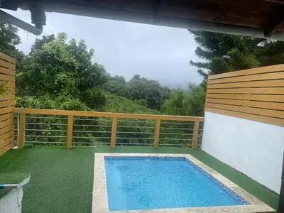 a swimming pool in a yard with a fence at La Casita Primavera-Cozy and Rustic in Piedra Blanca
