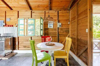 a table and chairs in a kitchen with wooden walls at La Casita Primavera-Cozy and Rustic in Piedra Blanca