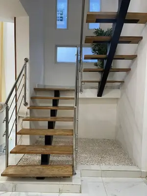a staircase with wooden treads in a house at Villa súper cómoda 3 habitaciones con piscina in Juan López