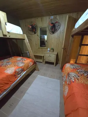 a bedroom with two bunk beds and a bathroom at La Casita De La Cueva in Cabo Rojo