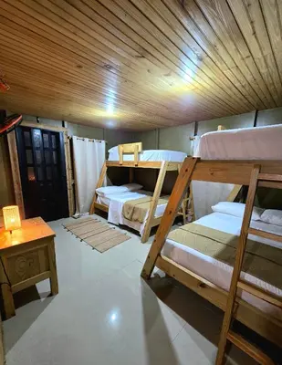 a room with two bunk beds and a table at La Casita De La Cueva in Cabo Rojo