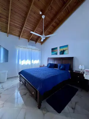 a bedroom with a blue bed and a wooden ceiling at Sosua Residence by CJDR in Sosúa