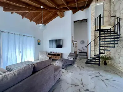 a living room with a couch and a staircase at Sosua Residence by CJDR in Sosúa