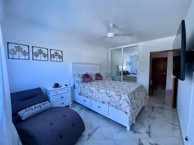 a bedroom with a bed and a mirror and a chair at Sosua Residence by CJDR in Sosúa