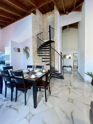 a dining room with a table and chairs and a staircase at Sosua Residence by CJDR in Sosúa
