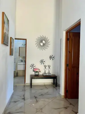 a hallway with a table and a mirror at Sosua Residence by CJDR in Sosúa