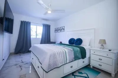a bedroom with a bed with blue pillows on it at Sosua Residence by CJDR in Sosúa