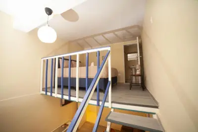 a bedroom with a staircase and a bed in a room at JEYMAR STUDIO rd in Santo Domingo