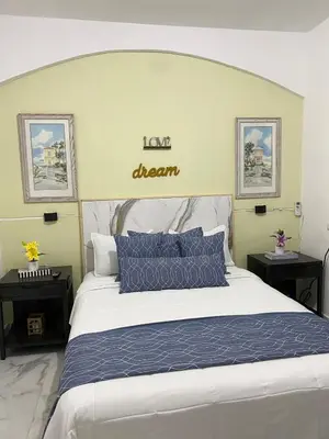 a bedroom with a large bed with blue pillows at Little Room Airport By Merengue House in Monte Adentro