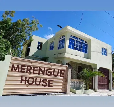 a house with a sign in front of a house at Little Room Airport By Merengue House in Monte Adentro