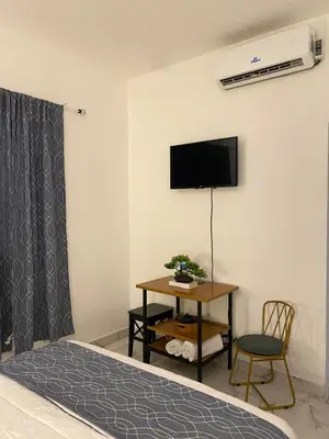 a bedroom with a bed and a table and a tv at Little Room Airport By Merengue House in Monte Adentro