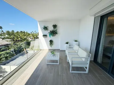 a balcony with white furniture and a view of the ocean at Luxury penthouse with panoramic ocean view in Punta Cana