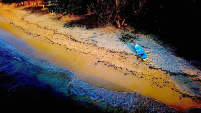 a blue boat sitting on the shore of a beach at The Cottage at Javo beach in Las Galeras