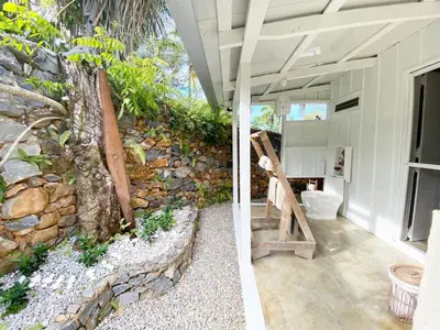 a bathroom with a stone wall and a toilet at The Cottage at Javo beach in Las Galeras