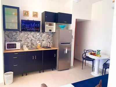 a kitchen with a refrigerator and a sink and a table at Vibe Residence Gorgeous Penthouse with Jacuzzi & outstanding Sea & Natural Preserve view in La Laguna