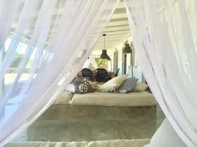 a bed with white curtains and pillows on a porch at The Bliss of JAVO BEACH in Las Galeras