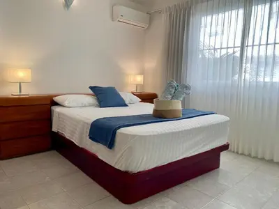 a bedroom with a large bed with blue and white sheets at Villas Princesa Beach Apartments in Punta Cana
