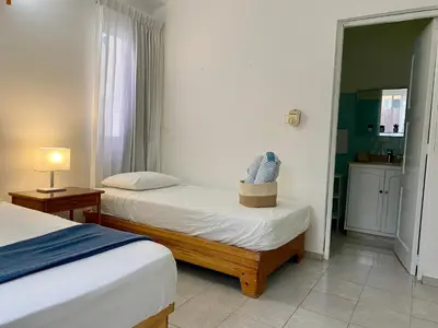 a hotel room with two beds and a mirror at Villas Princesa Beach Apartments in Punta Cana