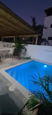 a blue swimming pool in a yard at night at Casa Madi in Bayahibe