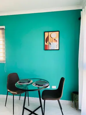 a table and chairs in a room with a blue wall at Acogedor apartamento in Colorado