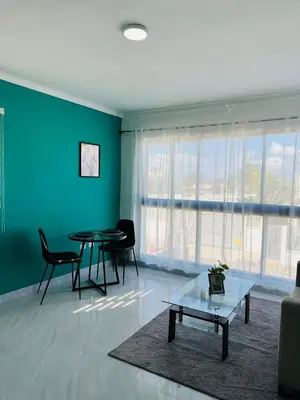 a living room with a table and chairs and a blue wall at Acogedor apartamento in Colorado