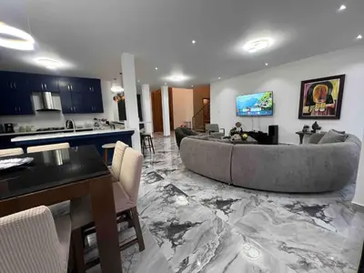 a living room with a large couch and a kitchen at Elegant, Modern style Villa in Playa Nueva Romana2 in Boca del Soco