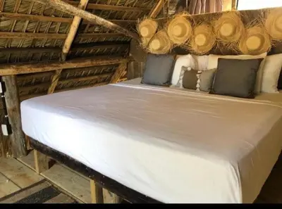 a large bed in a room with logs on it at Punta Cana Ecolodge In front of the beach Lavacama Costa Arrecife by BTC Crypto Group in El Eslabón