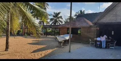 a house with a boat in a yard with a palm tree at Punta Cana Ecolodge In front of the beach Lavacama Costa Arrecife by BTC Crypto Group in El Eslabón