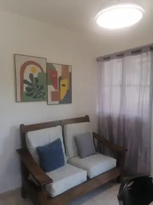 a couch with two pillows sitting in a room at Tu espacio en zona colonial in Santo Domingo