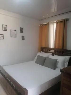 a bedroom with a large white bed with white pillows at Tu espacio en zona colonial in Santo Domingo