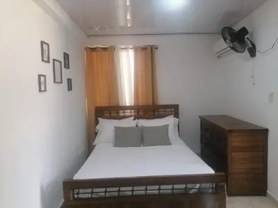a small bedroom with a bed and a fan at Tu espacio en zona colonial in Santo Domingo