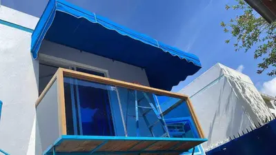 a house with a balcony with a blue awning at Acogedora Casa Vacacional in Colorado